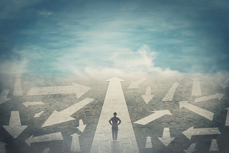 Person at a crossroads of arrows