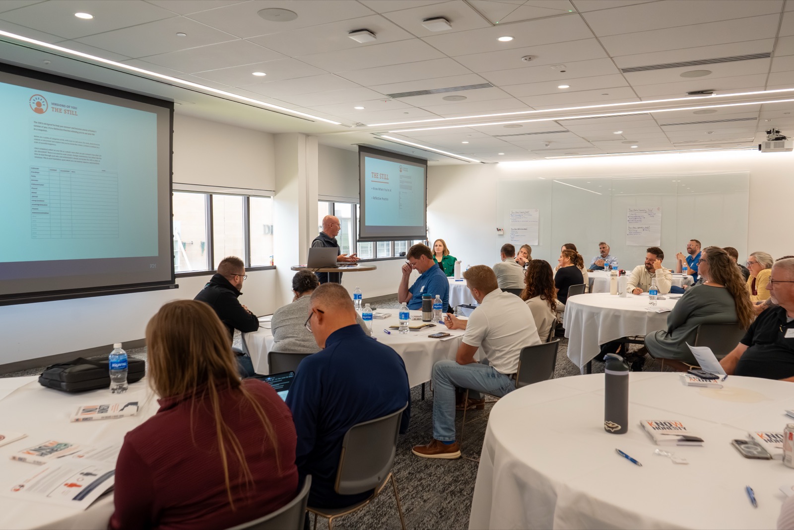 A full room at round tables during a Know Honesty&trade; workshop, Chris presenting at the front